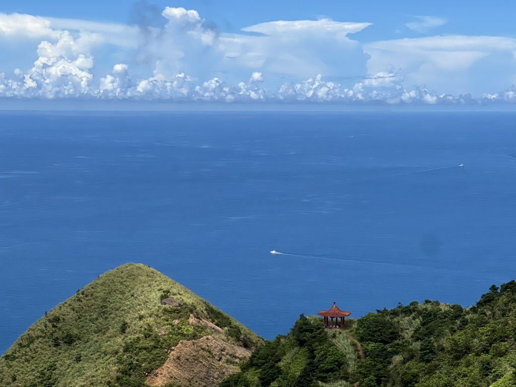 A pavilion overlooking the ocean and a rugged coastal landscape in Taiwan