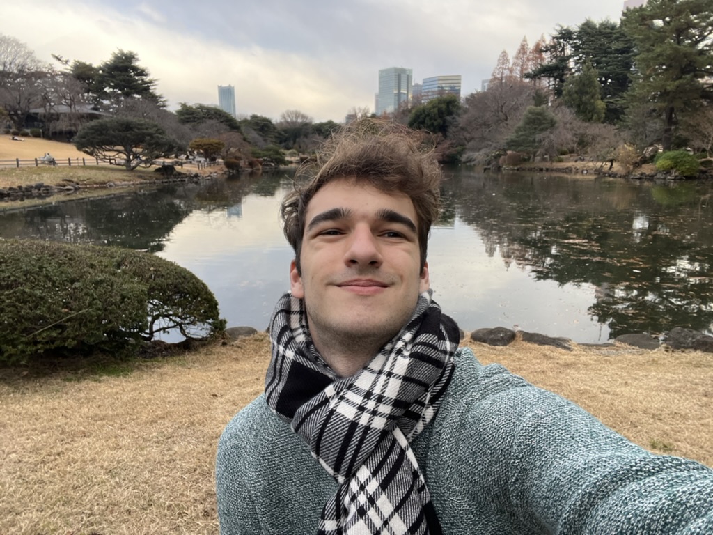 Jason smiling beside a pond in a Tokyo park