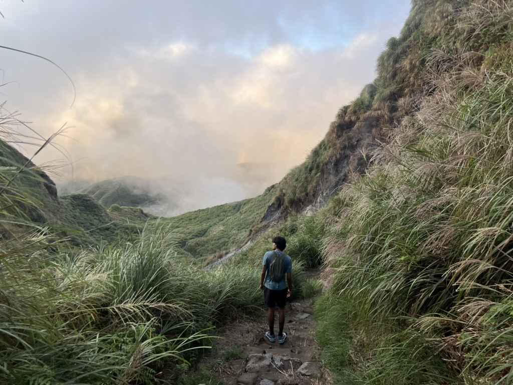 A person walking through clouds on a mountain trail in Yangmingshan
